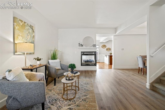 living room featuring a multi sided fireplace and hardwood / wood-style floors