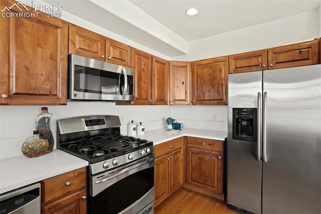 kitchen with light wood-type flooring and appliances with stainless steel finishes