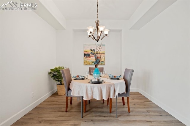 dining area with an inviting chandelier and light hardwood / wood-style flooring