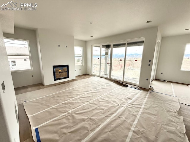 unfurnished living room featuring a glass covered fireplace