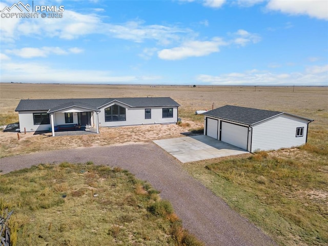 single story home with a garage, a front lawn, and a rural view