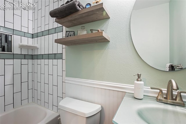 full bathroom with tiled shower / bath, vanity, and toilet