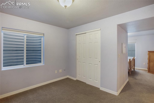 unfurnished bedroom with carpet, a textured ceiling, and a closet