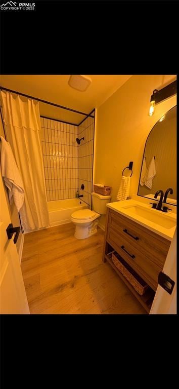 full bathroom with wood-type flooring, toilet, shower / tub combo, and vanity