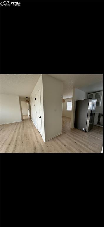 interior space featuring stainless steel fridge and light hardwood / wood-style flooring