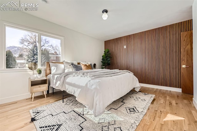 bedroom with hardwood / wood-style flooring and wooden walls