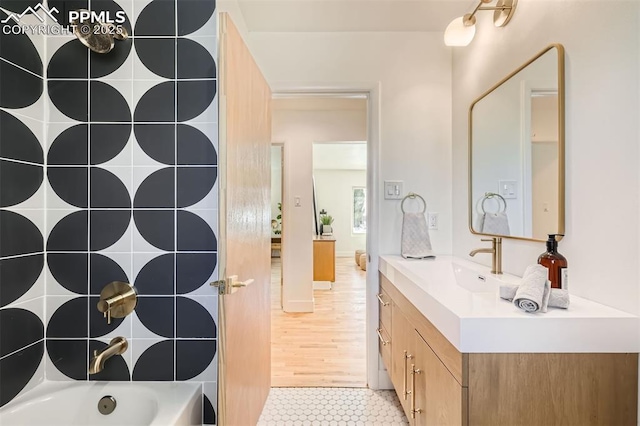 bathroom with tile patterned floors, a tub to relax in, and vanity