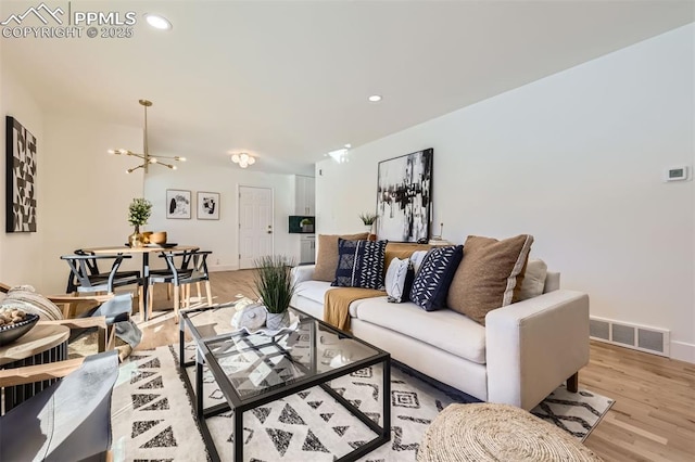 living room with a notable chandelier and light wood-type flooring