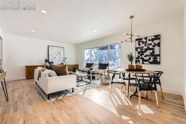 living room featuring an inviting chandelier and light hardwood / wood-style flooring