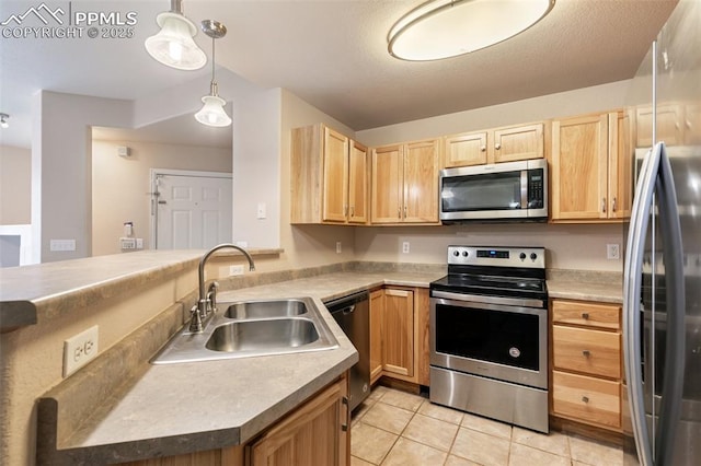 kitchen featuring appliances with stainless steel finishes, pendant lighting, light brown cabinetry, sink, and kitchen peninsula