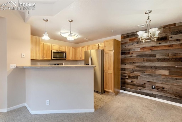 kitchen featuring stainless steel appliances, wood walls, light carpet, kitchen peninsula, and light brown cabinets