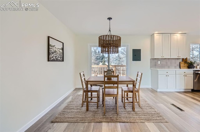 dining room featuring a chandelier, electric panel, and light hardwood / wood-style floors