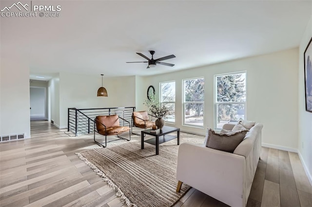 living room featuring light hardwood / wood-style flooring and ceiling fan