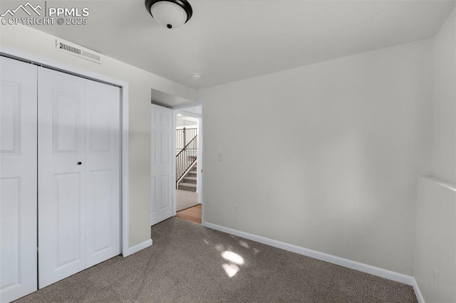 unfurnished bedroom featuring carpet flooring and a closet