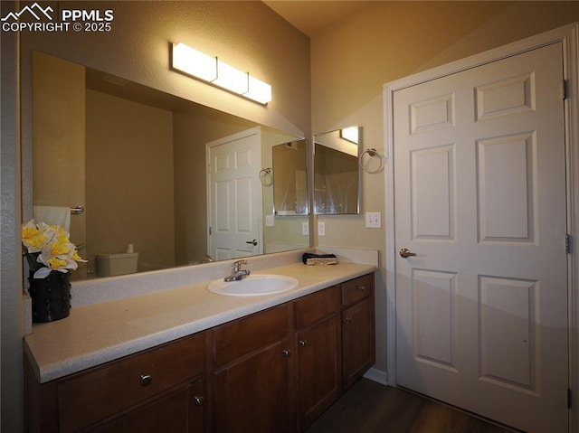 bathroom with hardwood / wood-style flooring, vanity, and toilet