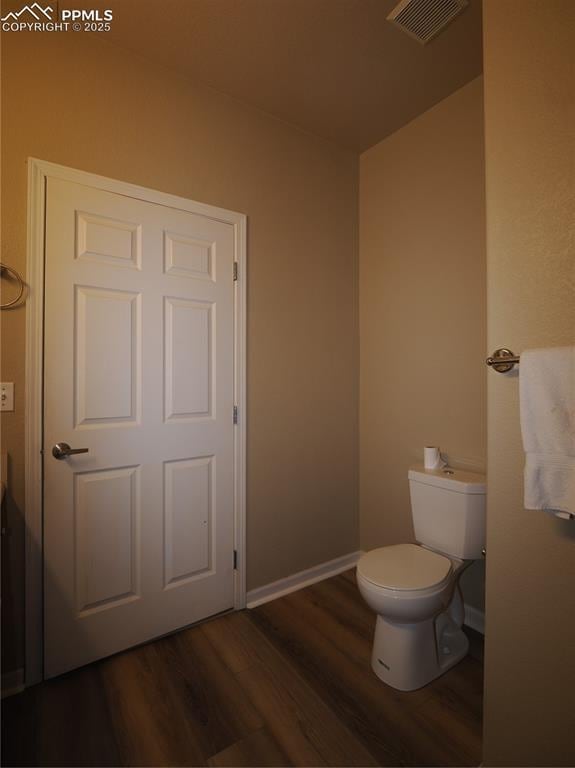 bathroom featuring hardwood / wood-style flooring and toilet