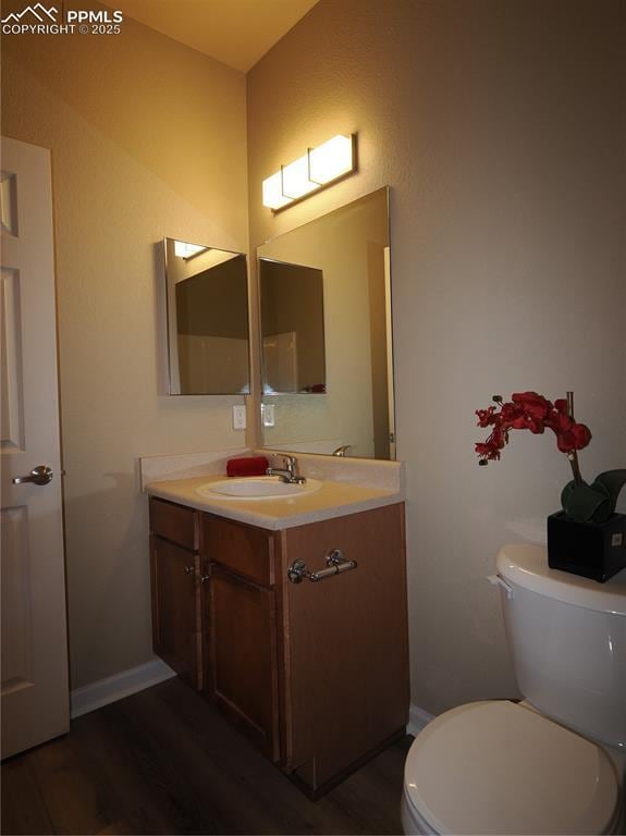 bathroom with vanity, hardwood / wood-style flooring, and toilet