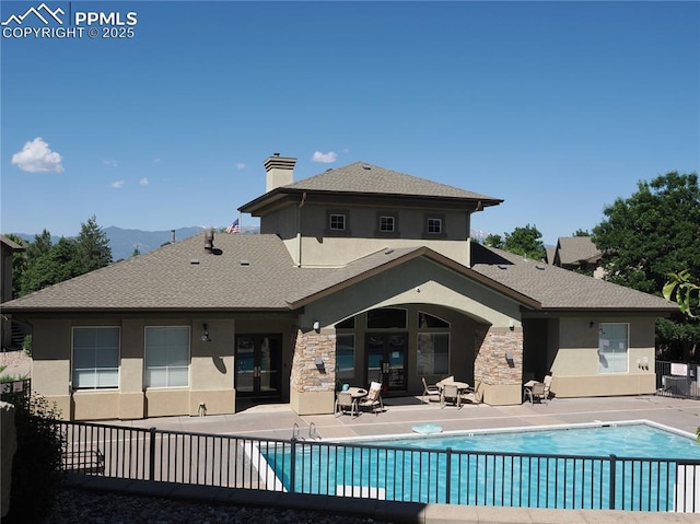 back of house featuring a community pool and a patio area