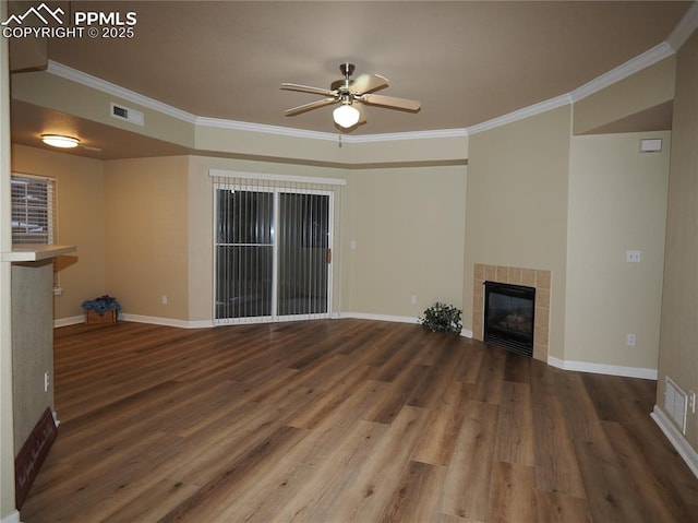 unfurnished living room featuring ceiling fan, ornamental molding, hardwood / wood-style floors, and a tile fireplace