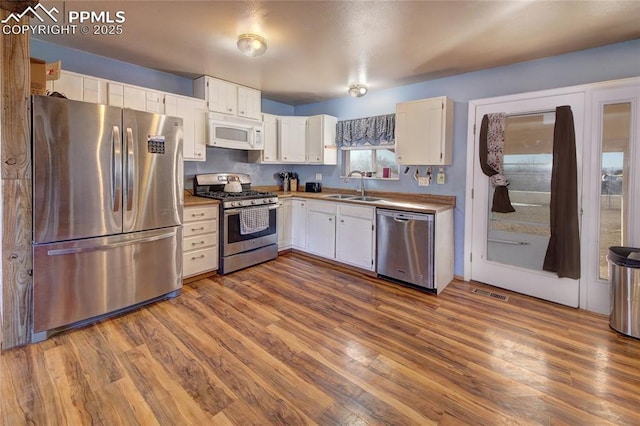 369 G St, Penrose, CO 81240 - kitchen featuring dark wood-type flooring, stainless steel appliances, and white cabinets