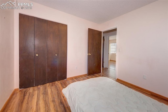 369 G St, Penrose, CO 81240 - bedroom with a closet, a textured ceiling, and light hardwood / wood-style flooring