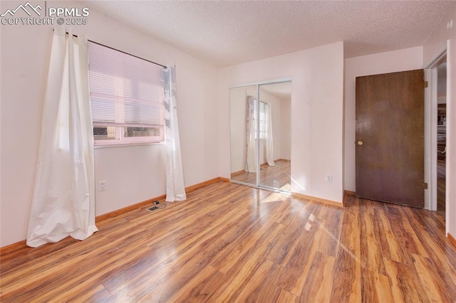 369 G St, Penrose, CO 81240 - unfurnished bedroom featuring hardwood / wood-style floors, a closet, and a textured ceiling