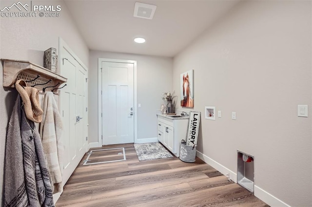 mudroom featuring wood-type flooring and sink