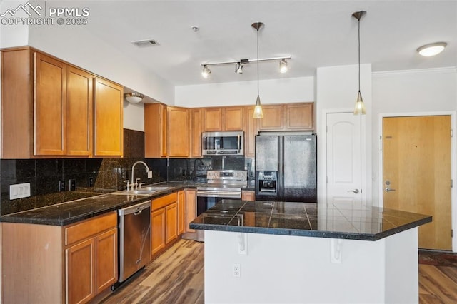 kitchen with pendant lighting, sink, tasteful backsplash, and appliances with stainless steel finishes