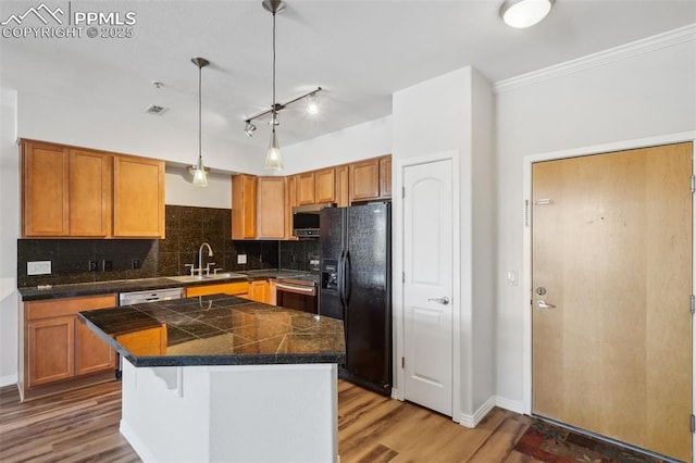 kitchen featuring sink, stainless steel appliances, a center island, tasteful backsplash, and decorative light fixtures