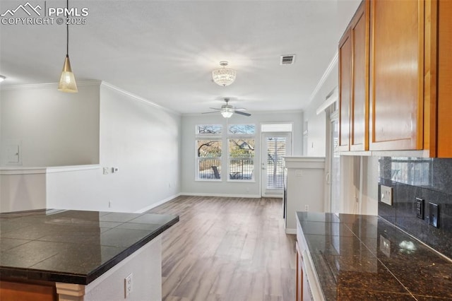 kitchen with crown molding, hanging light fixtures, decorative backsplash, and ceiling fan