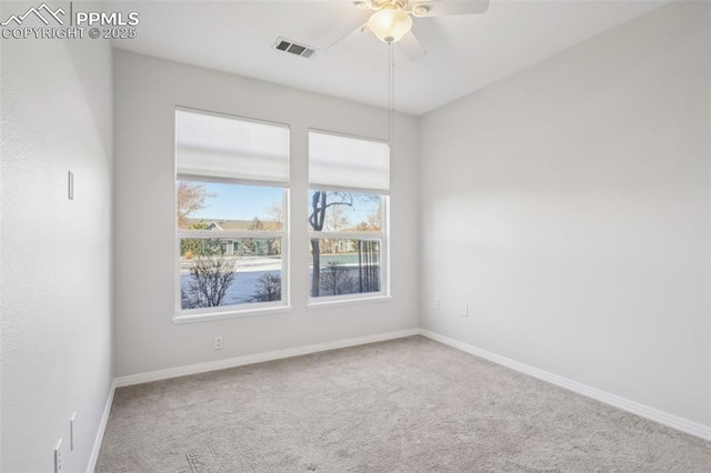 carpeted spare room featuring ceiling fan