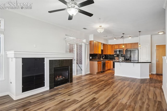 kitchen with sink, decorative light fixtures, a center island, appliances with stainless steel finishes, and a tile fireplace