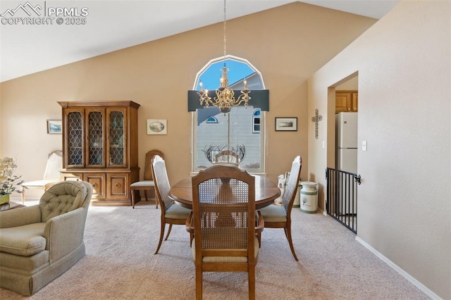 dining room with light carpet, a notable chandelier, and high vaulted ceiling