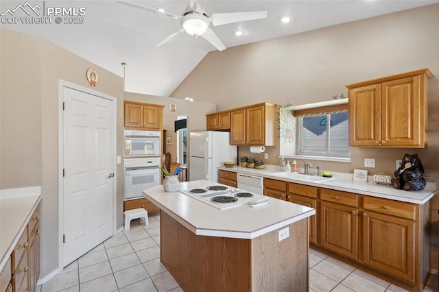 kitchen featuring vaulted ceiling, sink, a center island, light tile patterned floors, and white appliances