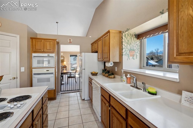 kitchen featuring lofted ceiling, sink, white appliances, and light tile patterned floors