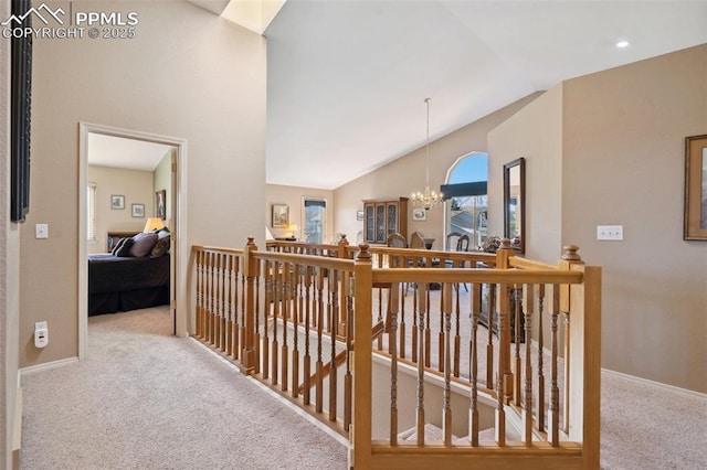 hall with vaulted ceiling, carpet floors, and an inviting chandelier