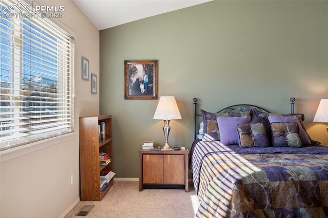 bedroom with multiple windows, vaulted ceiling, and light carpet