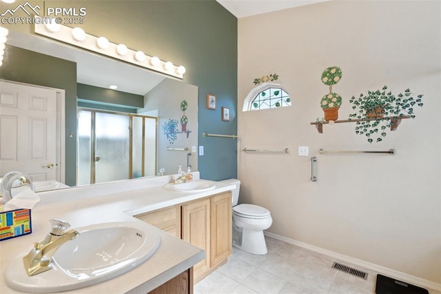 bathroom with tile patterned flooring, vanity, a shower with shower door, and toilet