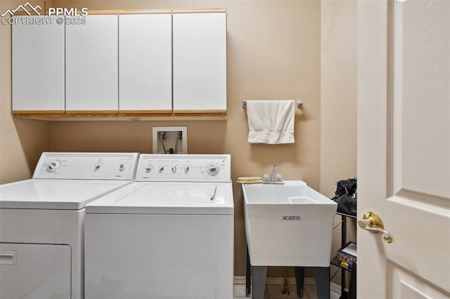 laundry room featuring cabinets, sink, and independent washer and dryer