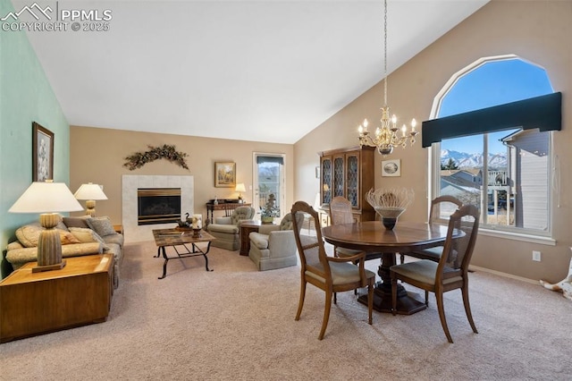 dining room with carpet flooring, a wealth of natural light, a notable chandelier, and a fireplace