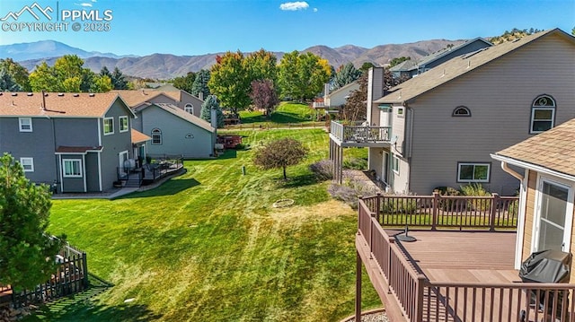 view of yard with a deck with mountain view