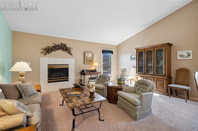 carpeted living room featuring lofted ceiling and a tile fireplace