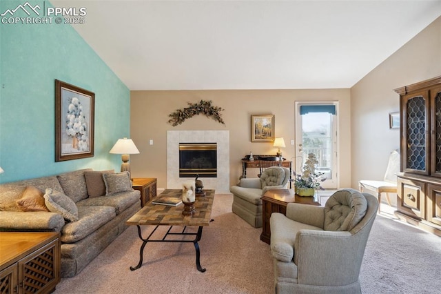 carpeted living room with a tiled fireplace and vaulted ceiling