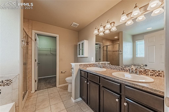 bathroom featuring tile patterned floors, vanity, toilet, and an enclosed shower