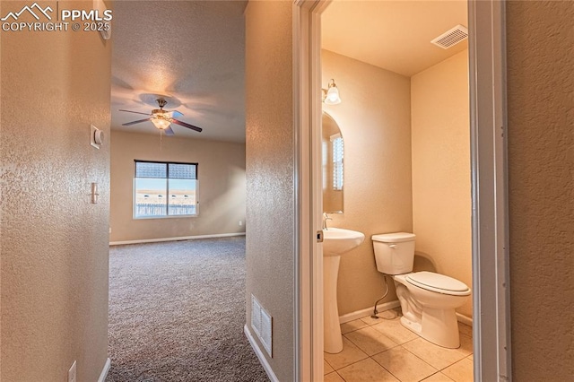 bathroom with tile patterned flooring, toilet, and ceiling fan