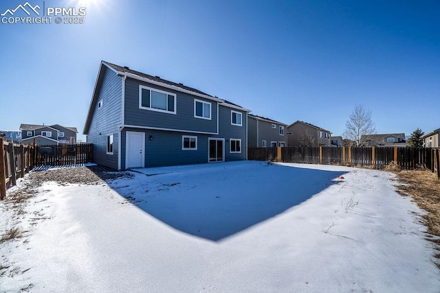 view of snow covered back of property