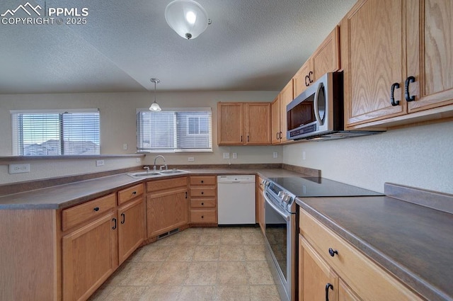 kitchen featuring appliances with stainless steel finishes, pendant lighting, sink, light brown cabinets, and a textured ceiling