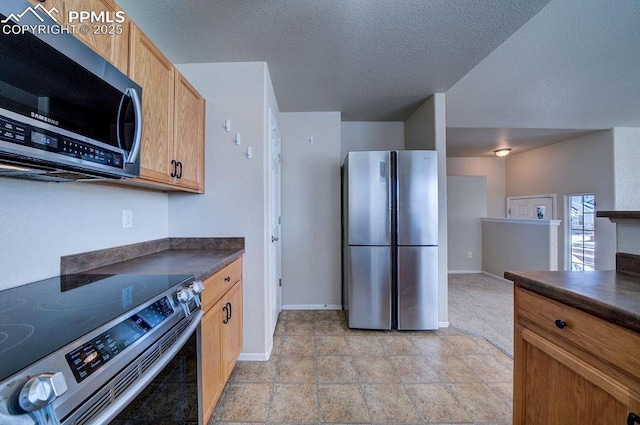 kitchen with appliances with stainless steel finishes and a textured ceiling