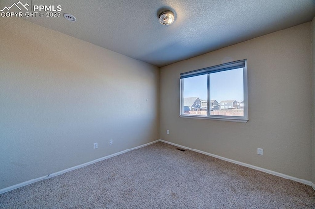 empty room featuring carpet floors and a textured ceiling