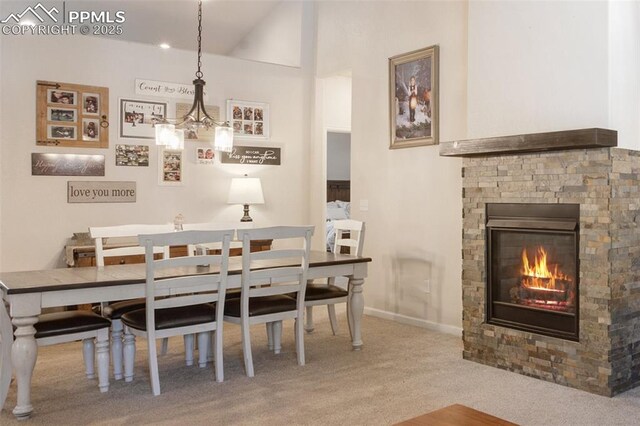 carpeted dining space featuring a stone fireplace